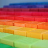 Grimm’s Stepped Counting Blocks - Large, featuring rows of non-toxic wooden building blocks arranged in a rainbow color gradient.