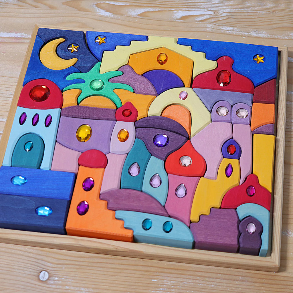 Grimm's Sparkling Mandala Orient is a vibrant wooden puzzle with city buildings, domes, stars, and crescent moon adorned with gems, arranged neatly in a square frame—an imaginative building toy. Ships in 1-2 weeks.