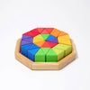 Grimm’s Medium Octagon (ships in 2-3 weeks) is a wooden puzzle set in an octagonal frame, featuring vibrant geometric building blocks—red, orange, yellow, green, blue, and purple triangles—arranged in a striking circular pattern.