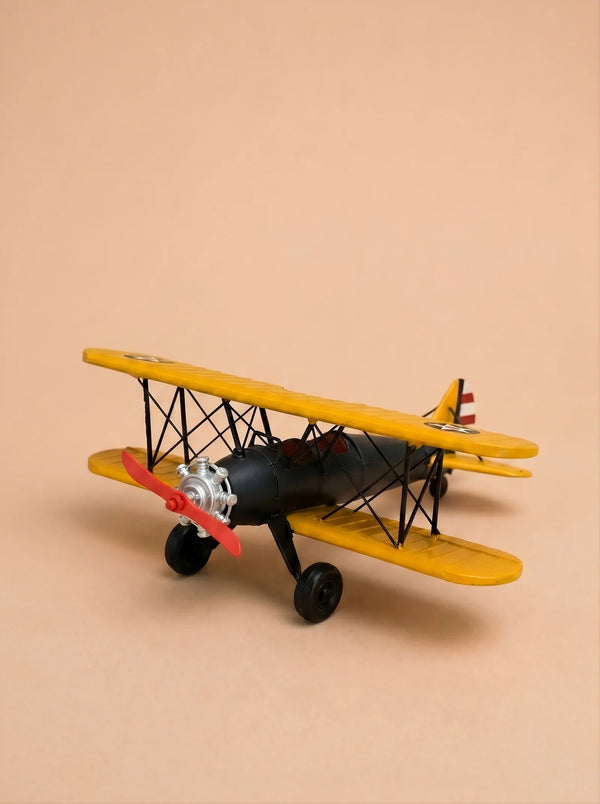 Little Forest Animals — The Aviator, a small model biplane featuring yellow wings, a black body, and a red propeller, is displayed on a beige background.