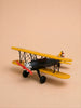 Little Forest Animals — The Aviator, a small model biplane featuring yellow wings, a black body, and a red propeller, is displayed on a beige background.