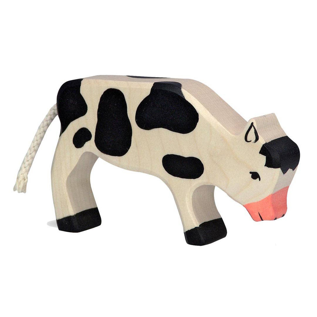 The Holztiger Calf, Grazing is a handcrafted wooden toy featuring a white body with black spots, black hooves, a rope tail, and a pink snout. Made in Europe, this figure stands on all fours and is perfect for timeless play.