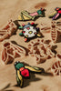 The Insect Cutter Set - Eco Playdough Tool features colorful clay insects and bugs surrounded by matching beige plastic insect playdough cutters, all arranged on a wooden surface in warm sunlight.