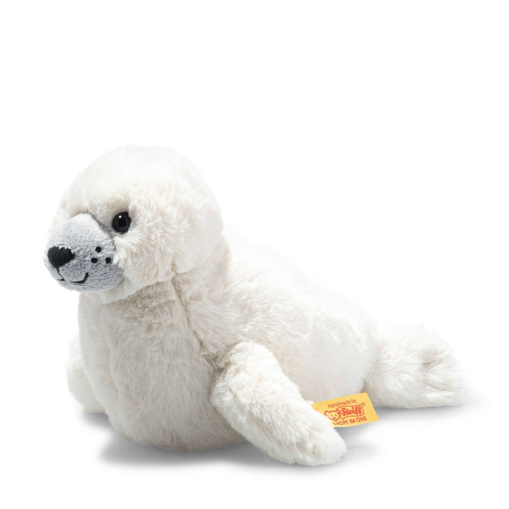 The Steiff Aro Baby Seal Pup is a soft, white plush toy with a light gray face, black stitched features, and a yellow Steiff tag—perfect as a cuddly stuffed animal for all ages.