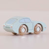 The No. 2 GT15 Jude, made in England, is a small, light blue vintage wooden car featuring simple painted details and wooden wheels, displayed on a smooth, light-colored surface—an ideal gift for kids who appreciate classic playthings.