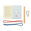 The Knot Game includes an open instruction booklet, a wooden dowel, a metal carabiner, and two ropes—one red and one blue—on a white surface for practicing essential and advanced knots.