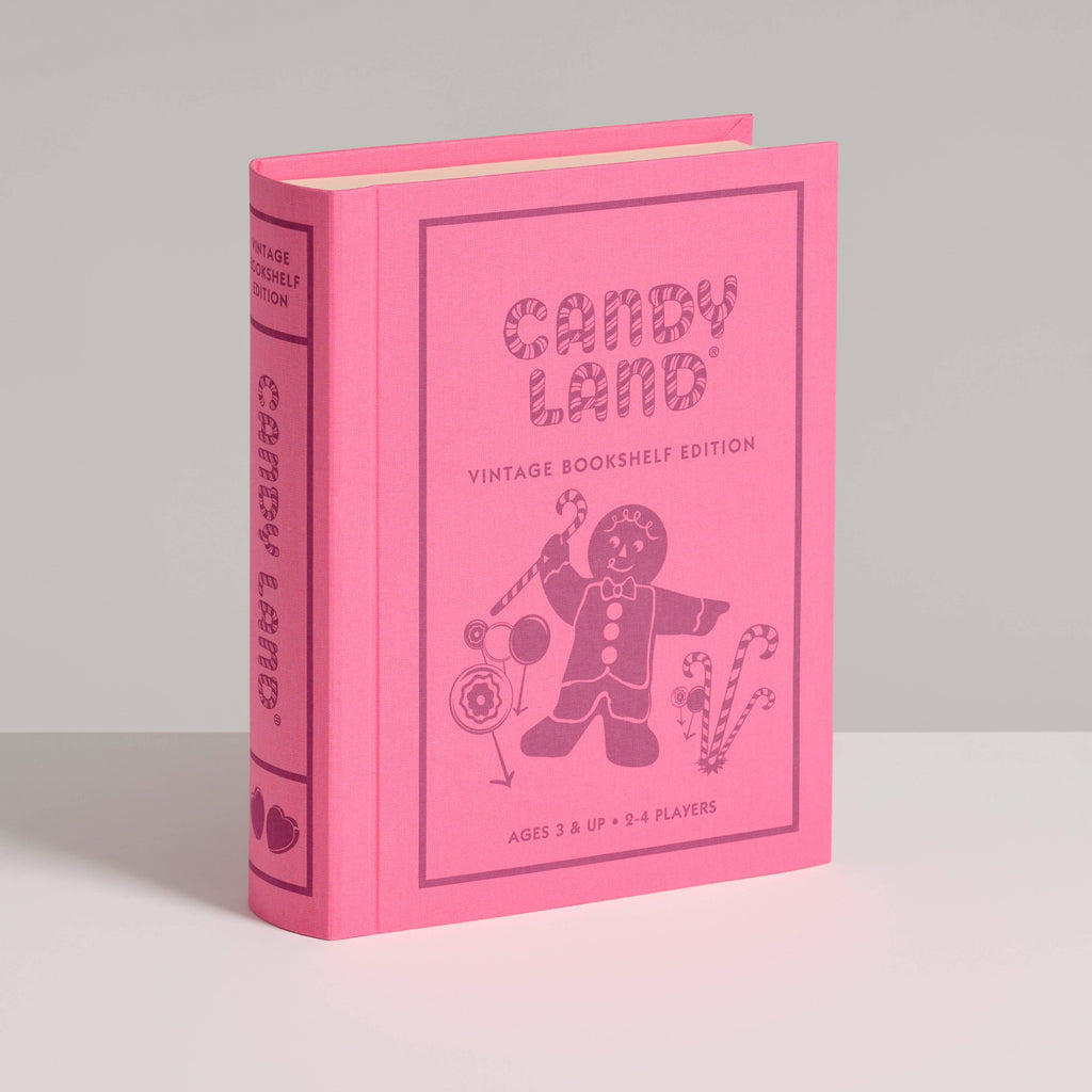 The Board Game: Candy Land Vintage Bookshelf Edition comes in a pink hardcover featuring classic CANDY LAND artwork with a gingerbread person, lollipop, and candy cane—ideal for fans of the vintage board game. Stands upright on any surface.
