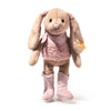 The Steiff Cowgirl Hoppie Rabbit is a plush bunny with floppy ears, a pink furry dress, matching scarf, pink star-embroidered boots, a soft friendly face, and a yellow tag on its left arm.