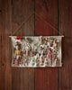 The Coral & Tusk North Pole Advent Calendar is a festive fabric calendar featuring stitched holiday scenes, small pockets for ornaments, candy canes, and mini characters, hanging from a wooden wall by a string.