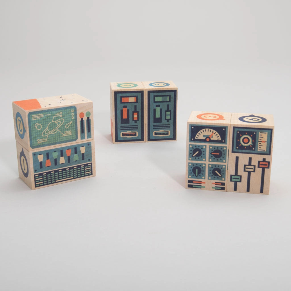 Three Uncle Goose Environments Space Blocks decorated with colorful, abstract designs that resemble control panels or machine interfaces of a rocket ship, positioned against a plain white background.