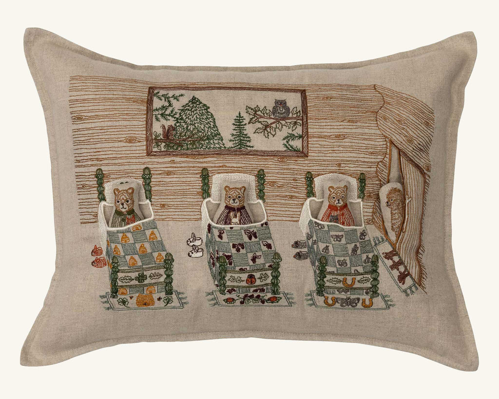 The Coral & Tusk Three Little Bears Pocket Pillow features an embroidered scene of three bears in beds inside a cabin, with rustic details and patterned quilts—a charming storybook accent for any nursery or reading nook. Ships in one week.