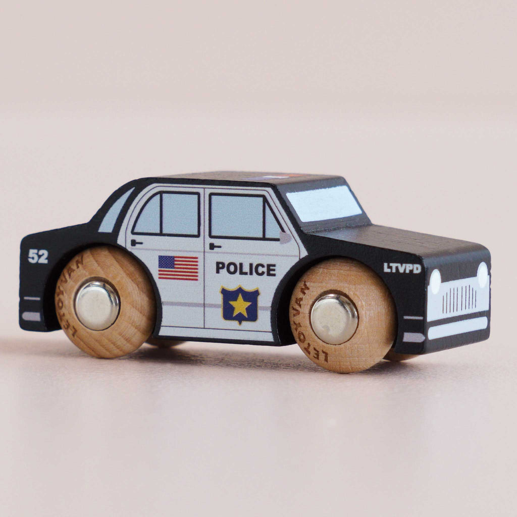 Introducing the No. 41 GT255 Sam—crafted in England, this classic wooden police car features hand-painted details such as an American flag, a star badge, and “POLICE.” With a sleek black-and-white body and light wood wheels, it’s perfect for imaginative play.