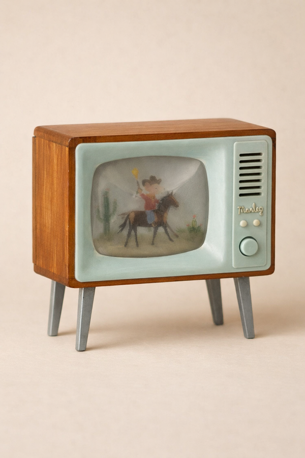 The Maileg Television, Mouse is a vintage-style wooden toy TV with a pale blue front and four legs, displaying a blurry cowboy and cactus scene—perfect for miniature home decor. Ships in one week.