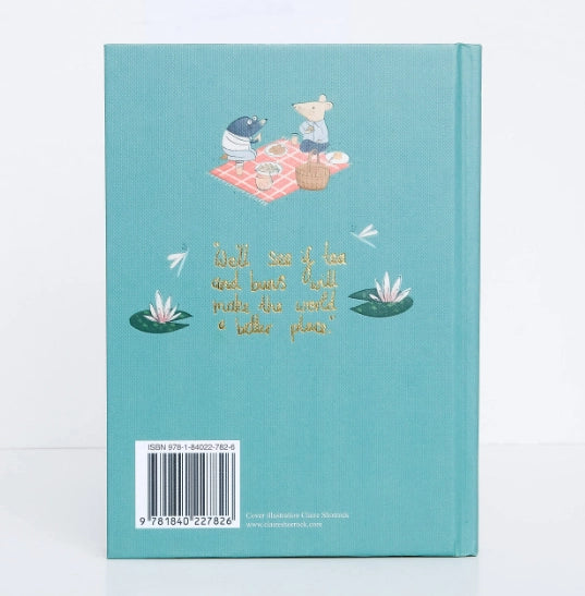 The back cover of "The Wind in the Willows" Collector's Edition (teal hardcover) depicts two animals picnicking on a blanket, surrounded by white flowers. Gold text reads, "We’ll see if the word bears teeth / make the word a better place." An ISBN barcode is at the bottom.