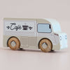 No. 11 GT65 Coco | Made in England is a wooden coffee van painted white and beige with “Café” and a coffee cup graphic on the side, featuring wooden wheels and a simple, cute design—perfect for imaginative storytelling or thoughtful gifting.