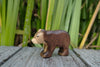 A Handmade Holzwald Small Bear - Walking wooden toy standing on a grey wooden surface.