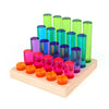 The Bauspiel Luminous Pillars feature a wooden base supporting translucent cylinders in orange, pink, blue, and green. Arranged in four rows of varying heights and colors, these educational toys create a vibrant gradient that inspires imagination and playful learning.