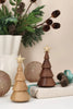 Two minimalist Spring Copenhagen The Christmas Tree, Thermo Beech ornaments, one light and one dark, each topped with a small gold-colored star.