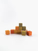 A set of Sabo Concept Mini Wooden Blocks - Flower Meadow is arranged in a small pyramid formation with nine colorful wooden pieces, while four extra blocks are scattered around the base against a plain white background. This educational toy inspires creative play and helps children develop fine motor skills.