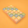 A set of Uncle Goose Classic ABC Blocks arranged on a light orange background, featuring a variety of letters in different colors and intricate borders.