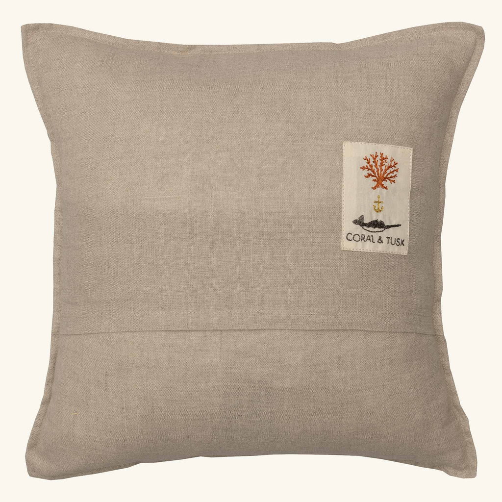 The Coral & Tusk Aspen Skiers Pillow is a square beige pillow with detailed embroidery, ideal for adding cozy winter decor to your space.