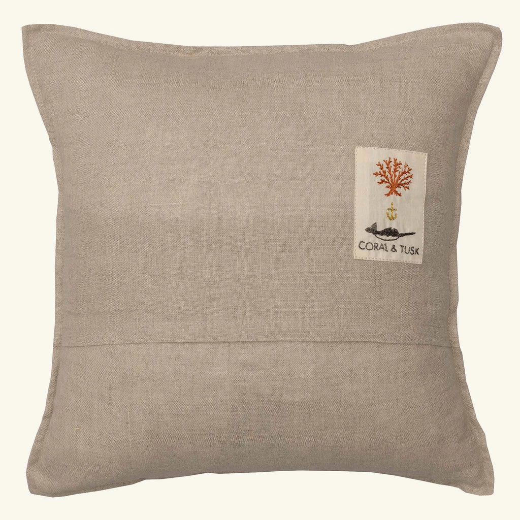 The Coral & Tusk Bat Wing Surprise Pillow is a square beige pillow with a red coral tree, anchor patch, and "CORAL & TUSK" on the back. Its linen-like fabric is perfect for pairing with other nature-themed decor like butterfly wings or bat plushies.