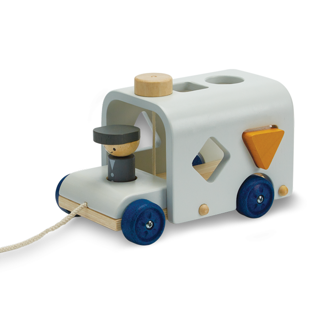 The Sorting Bus - Orchard Series is a wooden pull toy inspired by the classic bus design, featuring blue wheels, a peg driver, and shape sorter holes on its side. It includes a yellow triangle block that fits into one of the holes, and comes with a string at the front for pulling.