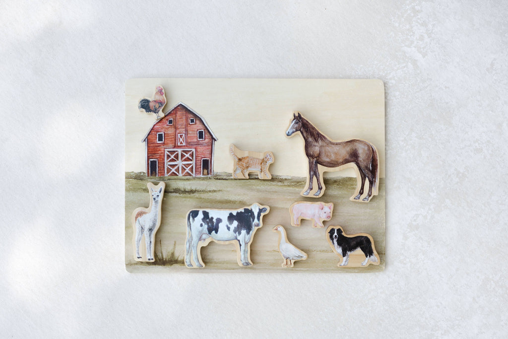 Introduce your child to classic farmyard friends with the Farm Animals Wooden Puzzle: A Tabitha Paige Puzzle. Featuring a red barn along with a horse, cow, pig, lamb, dog, rooster, duck, and llama on a subtly textured light background, this charming peg puzzle is the perfect toddler educational toy for helping little hands learn about animals and shapes.