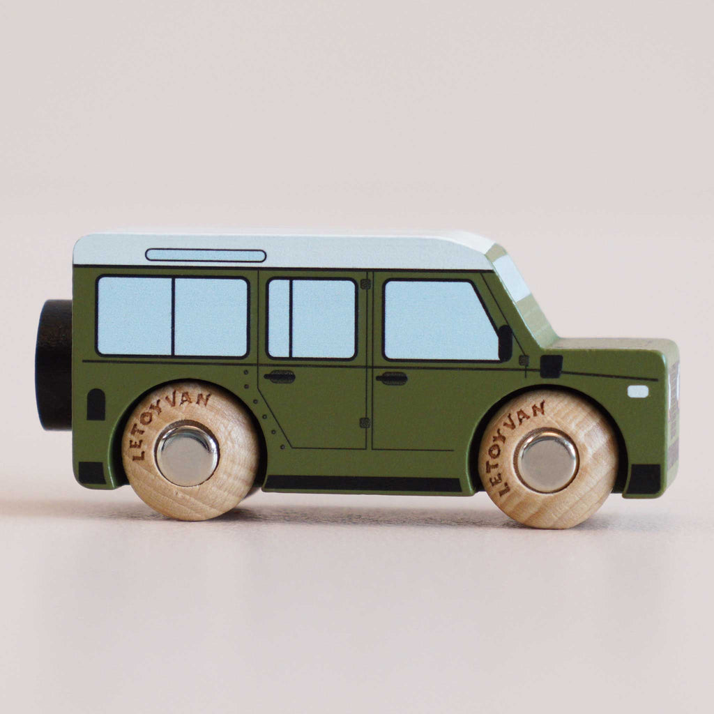 Introducing the No. 27 GT150 Archie | Made in England: a wooden 4x4 toy car designed as a green SUV with black accents and light blue windows, complete with natural wood wheels—perfect for imaginative play.