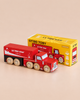 A vintage toy truck, this red wooden cola truck labeled “Le Toy Van Cola” sits in front of its yellow box packaging, which features an illustration of the truck and is marked with “No. 33 GT180 Toby | Made in England”—perfect for imaginative storytelling and nostalgic play.