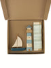 The Sabo Concept Sea Adventure Set features a sailboat, lighthouse toy, and striped block in blue, white, and natural wood tones, all neatly arranged in a brown open cardboard box.