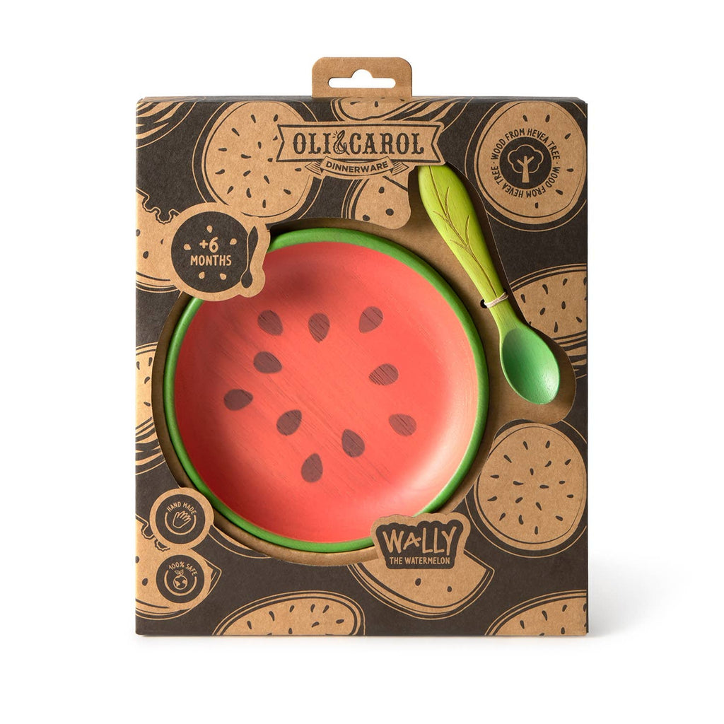 The Wally the Watermelon Plate & Spoon Set is a boxed Oli & Carol baby dinnerware set with a non-toxic watermelon slice plate and green wooden spoon, suitable for babies 6 months and up.