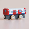 No. 48 GT290 Tim | Made in England is a wooden toy train car with a black base, painted in red, white, and blue, featuring two natural wood wheels on each side—perfect for imaginative play inspired by metro transport systems. Displayed on a plain beige background.