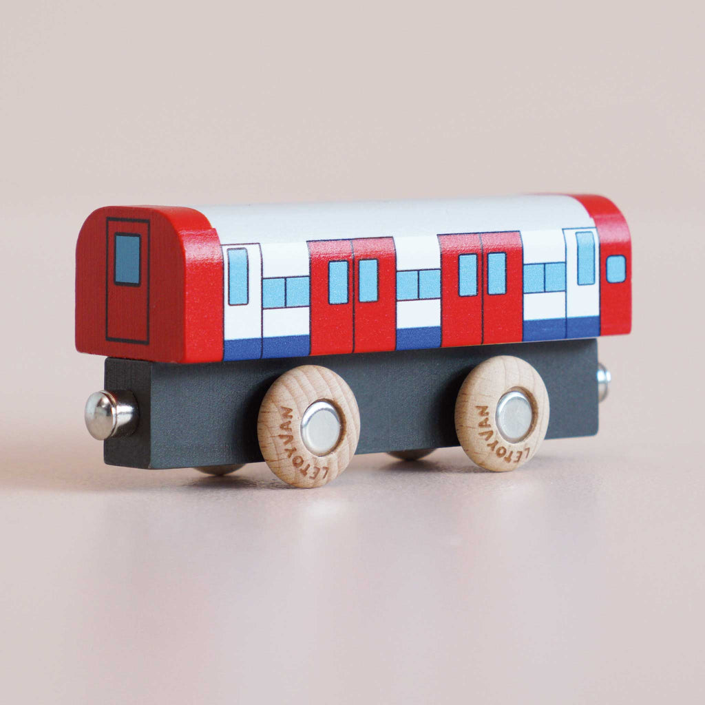 No. 48 GT290 Tim | Made in England is a wooden toy train car with a black base, painted in red, white, and blue, featuring two natural wood wheels on each side—perfect for imaginative play inspired by metro transport systems. Displayed on a plain beige background.
