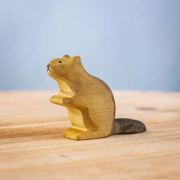 The Bumbu Handmade Wooden Beaver is a small, handcrafted figurine with a brown body and dark tail, standing upright—an eco-friendly, charming addition to any Montessori play space.