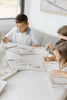 Two children sit at a table using Winnie-the-Pooh: Pooh’s Birthday Surprise (Water Reveal) books with specialized pens for a no-mess activity.