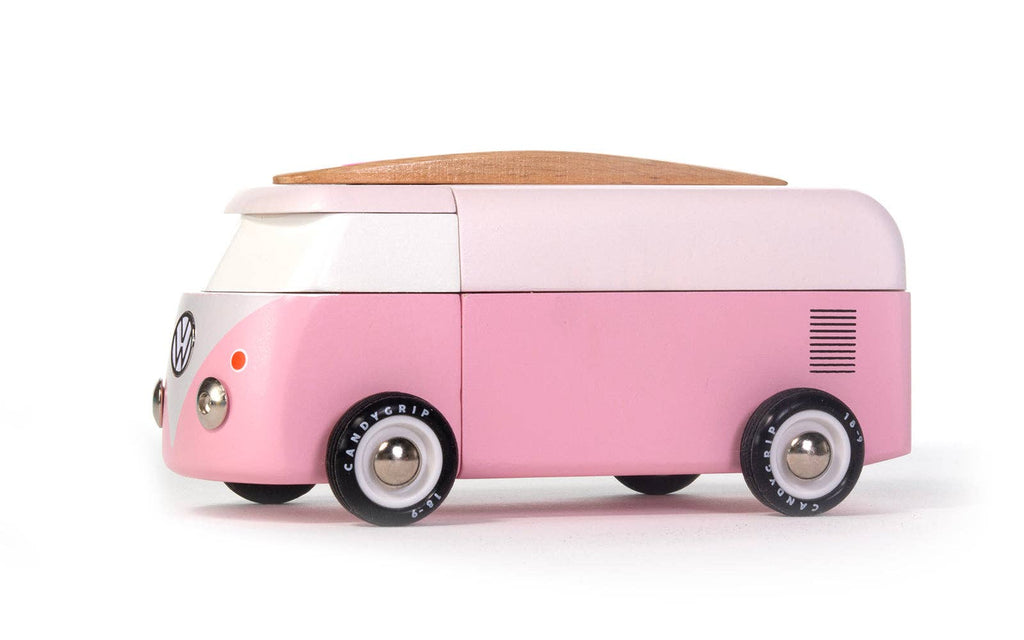 The VW Beach Bus Pink is a toy Volkswagen Type 2 van in pink and white, featuring a wooden roof, magnetic camper top, black wheels, and a VW logo on the front, shown on a white background.
