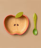 The Pepa the Apple Bowl & Spoon Set features a wooden apple-shaped bowl with green leaf detail and seed designs, plus a matching green spoon with leaf pattern—an adorable, non-toxic Hevea wood baby tableware set on a beige background.