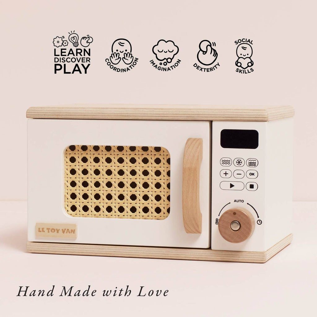 The Wooden Microwave (ships in one week) is perfect for play kitchens, featuring a wicker-style door and control panel. Icons show it boosts coordination, imagination, dexterity, and social skills. "Hand Made with Love from sustainable wood.