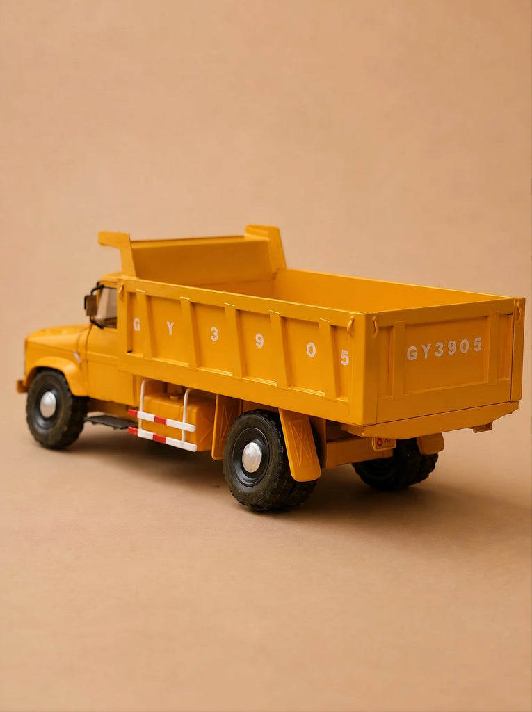 A yellow handcrafted dump truck from the Little Forest Animals — Big Yellow Truck collection, featuring the number GY3905 on its side and back, is displayed against a plain beige background. This FAW model captures realistic details, making it an ideal choice for collectors and enthusiasts.