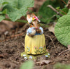 The Wee Forest Folk Tiny Collectible - Bluebird of Happiness features a rabbit in a flower crown and yellow skirt, holding a blue and white bird, standing on soil—a charming hand-sculpted miniature for collectors.