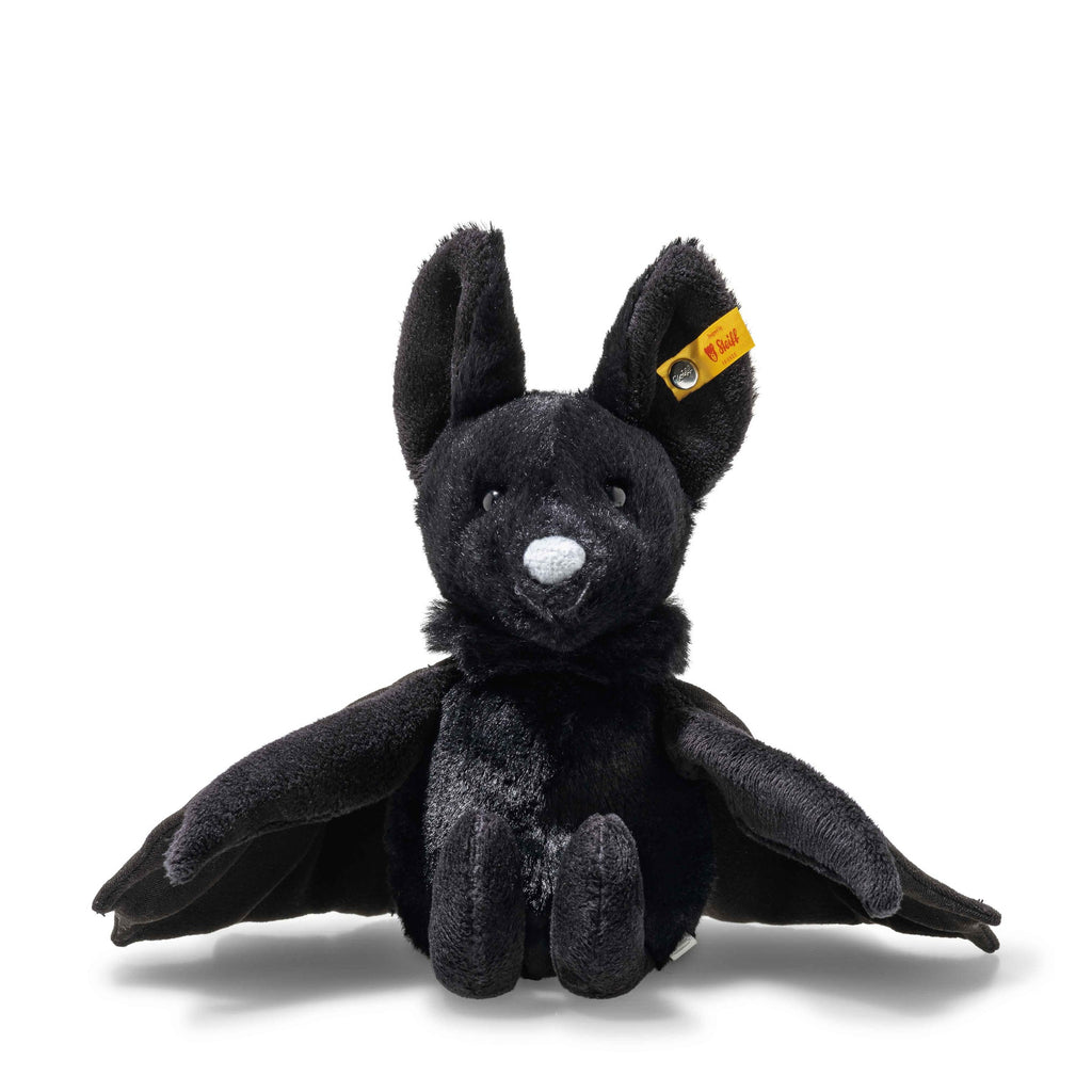 Steiff Boris the Spooky Bat sits upright with large ears, outstretched wings, a white nose, and a yellow ear tag. Perfect for Halloween décor, this plush toy is showcased on a white background.