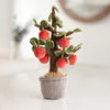 The Bukowski - Apple Tree is a plush fabric tree with smiling red apples, green leaves, and a soft brown trunk in a pot—ideal for imaginative play and toy safety, shown on a light-colored surface.