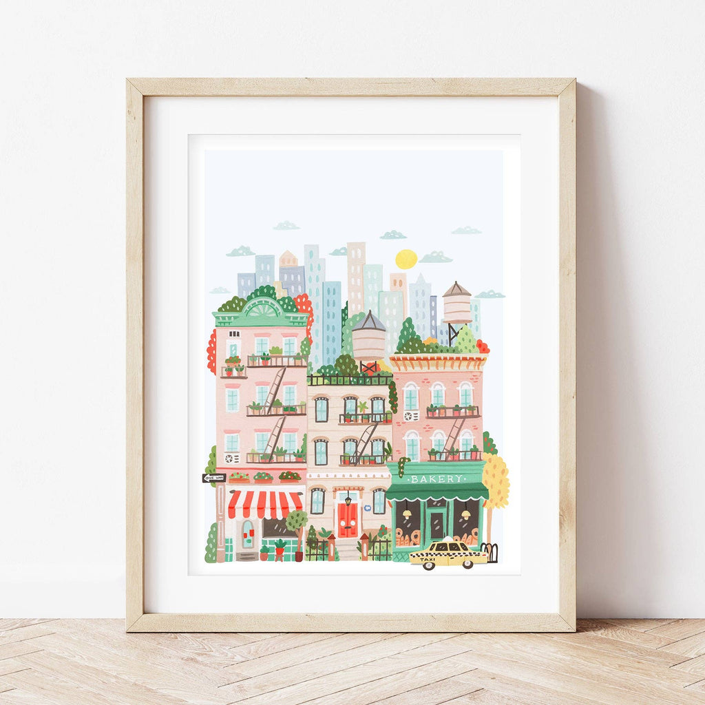 The Paint By Number Kit - New York features a vibrant cityscape with colorful buildings, a bakery, fire escapes, potted plants, a yellow taxi, and skyscrapers—perfectly displayed against a white wall on a wooden floor.