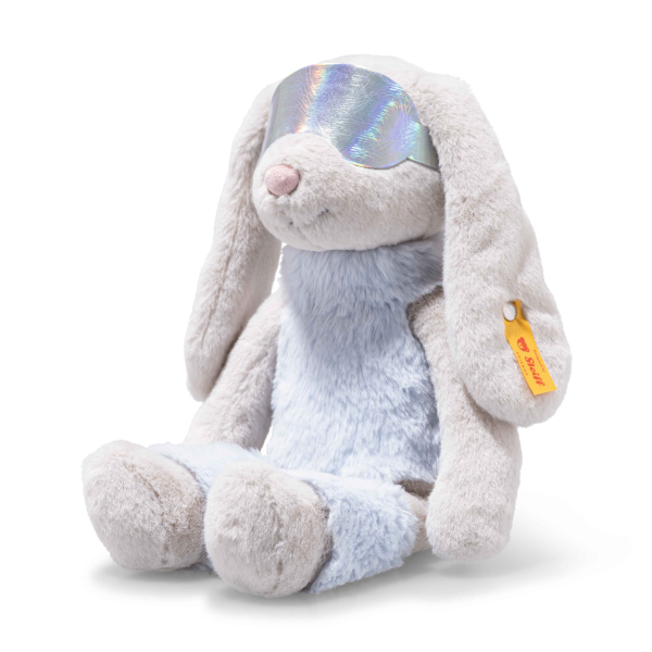 The 12-inch Steiff Hoppie Rabbit in Ski Outfit sits upright, featuring light gray fur, floppy ears, a soft blue belly, iridescent glasses, and a yellow tag on its left ear.