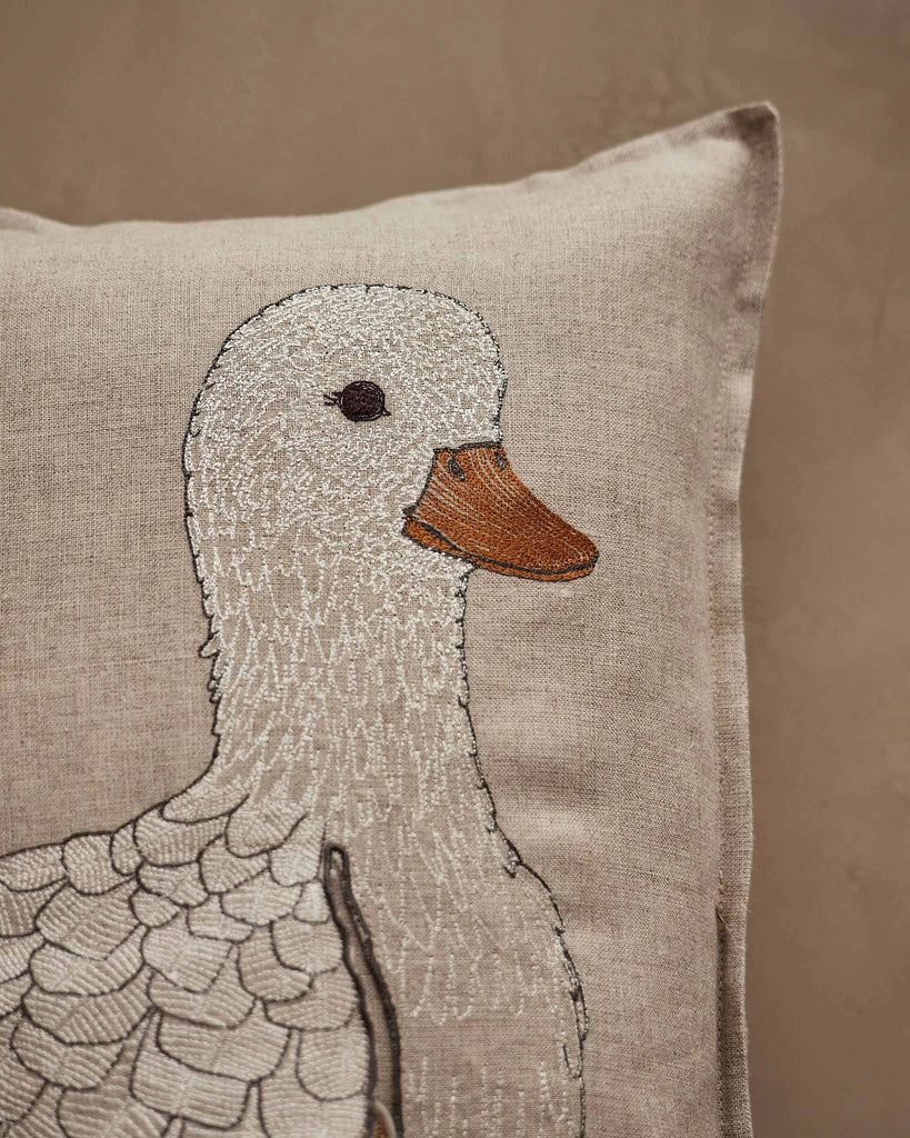 The Coral & Tusk Mama Duck Pocket Pillow is a beige pillow with an embroidered white duck in profile. Add removable felt ducklings for a playful, charming touch to your decor.