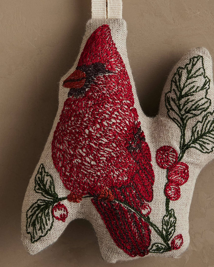 Coral & Tusk Red Cardinal Ornament featuring a fabric design of a red cardinal perched on a branch with leaves and red berries on natural linen.