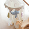 The Nautical Dreams Mobile, featuring a plush gray seal, yellow fish with ribbon fins, and pink fish, hangs above a wooden rocking horse to add charming nautical decor to the softly lit nursery.