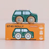 A small blue wooden toy car, the No. 7 GT45 Molly | Made in England, sits atop an orange box labeled “GT45 MOLLY.” This charming British toy comes with a box decorated with illustrations and symbols denoting sustainable wood, suitability for ages 2+, made in England, and child-safe paints.
