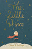 The cover of The Little Prince | Collector's Edition | Hardcover features a blond boy in blue clothes and a red scarf on a white hill, looking at golden stars beneath the gold-script title, with the author's name shown at the bottom.